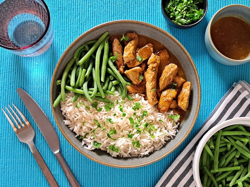 Chinesisches Schweinefleisch in würziger Sauce mit Reis und grünen Bohnen