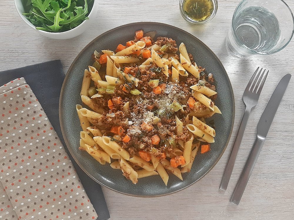 Vegan Ragout mit Penne mit Rosmarinöl, veganem Reibekäse und Rucola