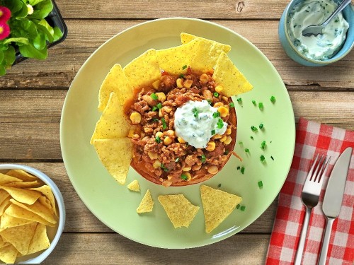 Kürbisschiff Chili sin Carne mit Sourcream und Tortillas Chips 