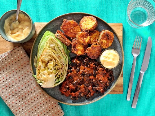 Schwarze Bohnen in spanischer Tomatensauce mit gebackenen Käsekartoffeln, Aioli und Bratsalat 