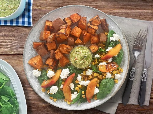 Süßkartoffelteller mit Avocadodressing mit Feta, Mais und gebratenen Nektarinen