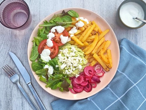 Veggie Teller mit Avocado-Feta-Mash mit Würzpommes, pickled Onions und Joghurtcreme
